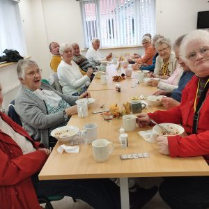 Image shows a group of people enjoying harvest soup.